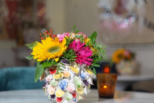 un jarrón lleno de flores de colores en una mesa en Bubbles & Bed en Bilthoven