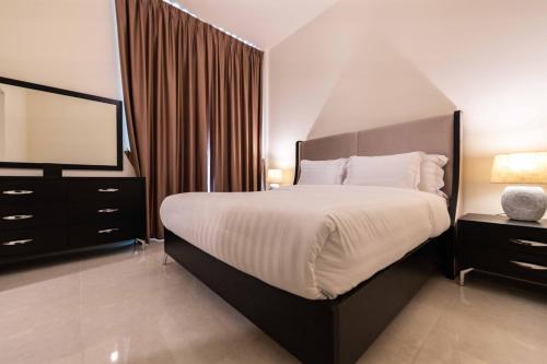 a bedroom with a large bed and a mirror at Blue Ocean Holiday Homes - Polo Residence C1 in Dubai