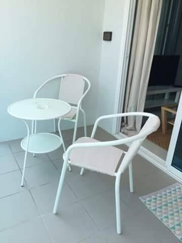 a room with two chairs and a table and a laptop at Grandblue Condo 410 in Mae Pim