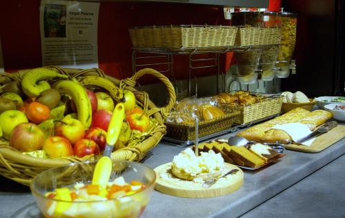 a table with baskets of fruits and other food on it at The Originals Boutique, Villa Montpensier, Pau in Pau