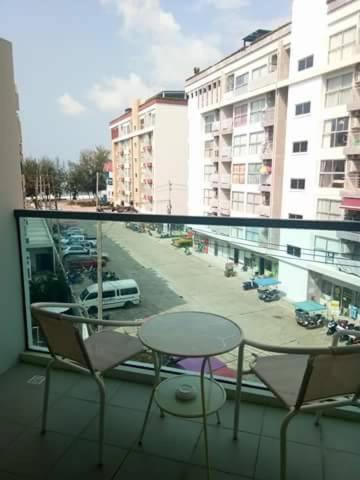 a balcony with a table and chairs and a view of a street at Grandblue Condo 410 in Mae Pim
