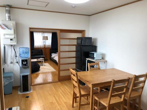 een woonkamer met een tafel en een eetkamer bij Kurashiki Base Inarimachi in Kurashiki