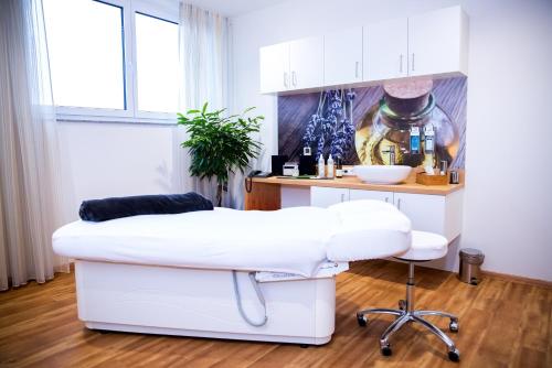 a white barber chair in a room with a table at Plus Punkt Private Spa in Weingarten