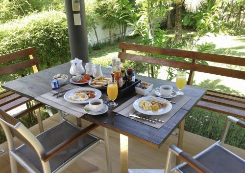 a breakfast table with food and drinks on a patio at Tha Lane Bay Villas in Tha Lane Bay