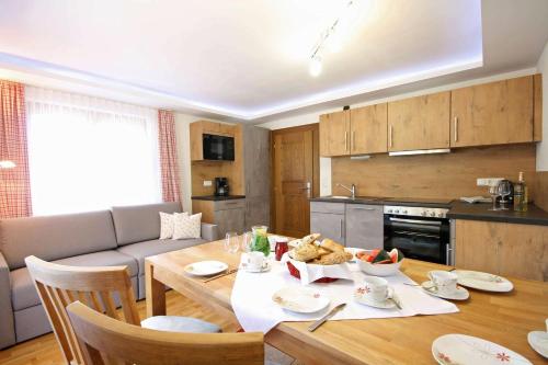 a kitchen and dining room with a table with food on it at Almliesl NEUK-467 in Neukirchen am Großvenediger
