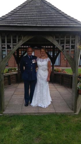 a bride and groom standing under a gazebo at The Abbey Hotel and conference centre in Minster
