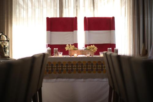 a table with red and white curtains and a table with chairs at The Swiss Hotel Freetown in Freetown