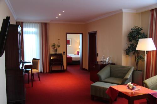 a hotel room with a living room with a bedroom at Hotel Amaris Bremerhaven in Bremerhaven