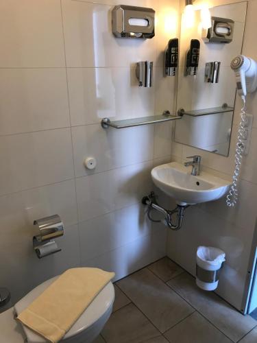 a bathroom with a toilet and a sink at CREO Munich City in Munich