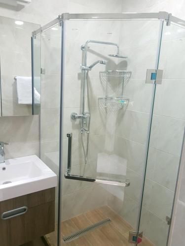 una ducha con una puerta de cristal junto a un lavabo en M&N apartments en Ereván
