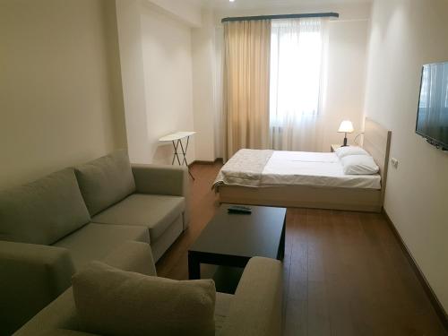 una pequeña sala de estar con cama y sofá en M&N apartments en Ereván