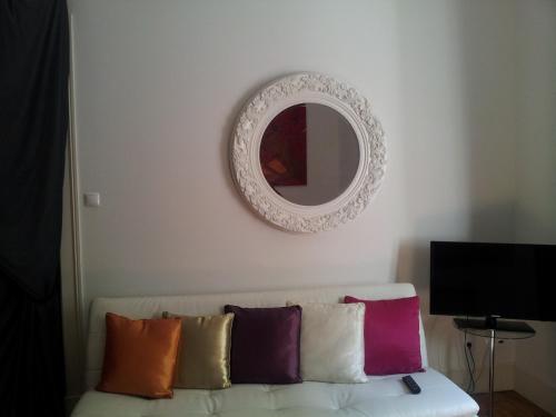 a mirror on a wall above a couch with pillows at Whatever Art B&B in Lisbon