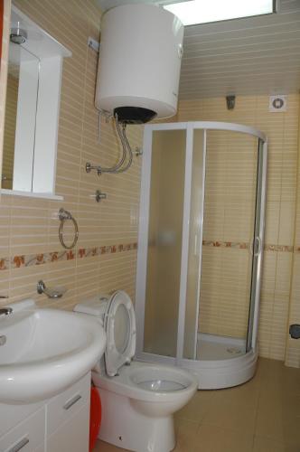 a bathroom with a shower and a toilet and a sink at Apartments Dragišić in Sveti Stefan