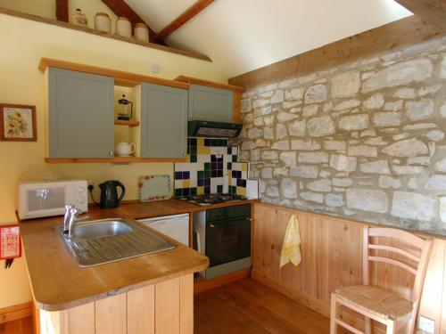 a kitchen with a sink and a stone wall at Sunnyside in Taunton