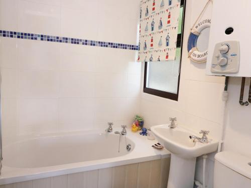 a white bathroom with a tub and a sink at Captain's Cabin in Aberystwyth