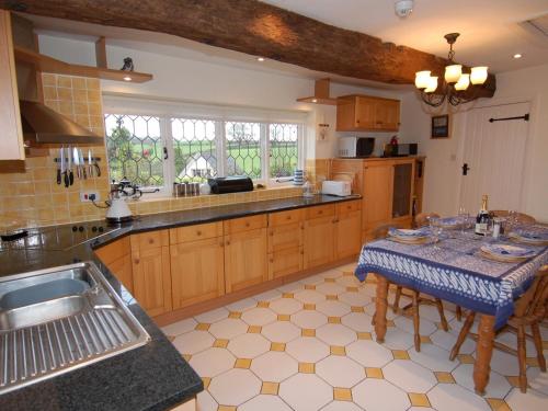 een grote keuken met een tafel en een wastafel bij Appletree Cottage in Ilsington