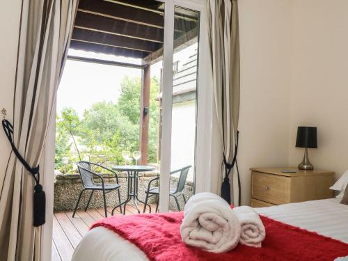a bedroom with a bed and a balcony with a table at Valley Lodge 48 in Callington