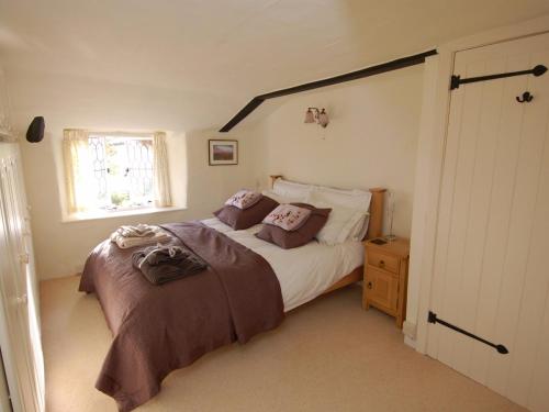 ein Schlafzimmer mit großem Bett und Fenster in der Unterkunft Appletree Cottage in Ilsington