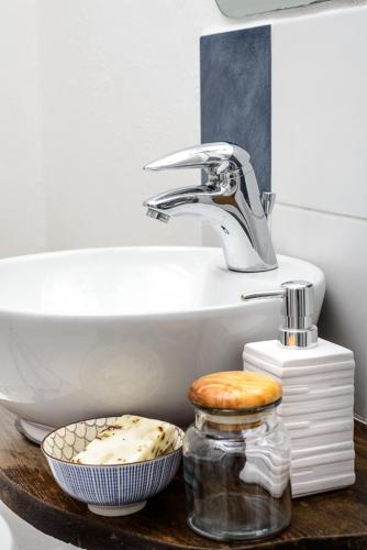 a bathroom with a sink and a bowl on a table at Al vicolo del Gallo in Varallo