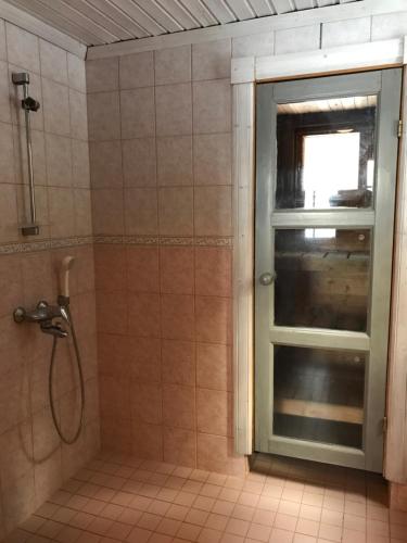 a shower with a window in a bathroom at Ylä-Saarikko Holiday Cottages in Kuusa