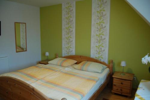 a bed in a bedroom with green walls at Weingut Klein-Götz in Bruttig-Fankel