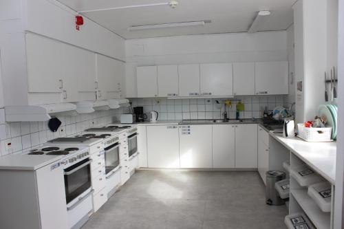 a white kitchen with white cabinets and white appliances at STF Östersund Ledkrysset in Östersund