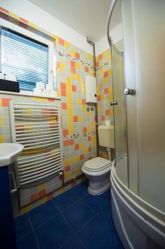 a bathroom with a toilet and a shower and a sink at Apartmani Galić in Ploče