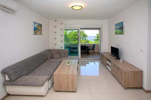 sala de estar con sofá grande y TV en Apartments Maslina II, en Njivice