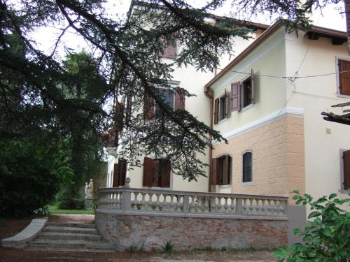a white house with a stone fence and stairs at Antica Scuderia in Buttrio
