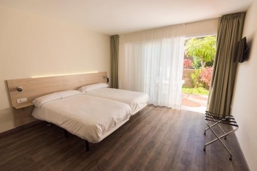 a bedroom with a bed and a large window at Paraiso del Sol y Paradero in Playa de las Americas