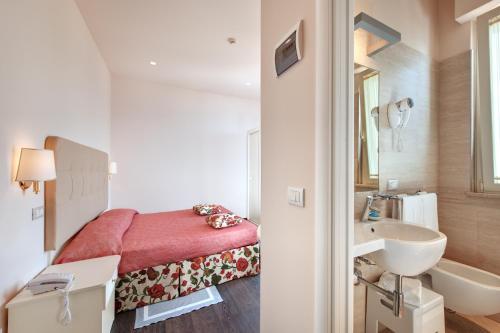a small bathroom with a bed and a sink at Hotel Bahia in San Benedetto del Tronto