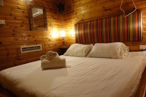 a bedroom with a bed with a stuffed animal on it at Cabin Resort in Moshav Ramot