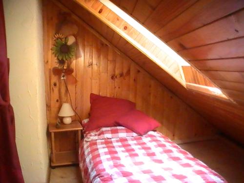 HazelbourgにあるGîte de la baerenbachの木製の部屋にベッド1台が備わるベッドルーム1室があります。