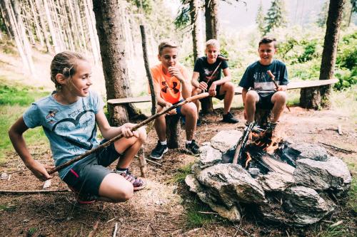 a group of children sitting around a camp fire at Kinderhotel Stegerhof in Donnersbachwald