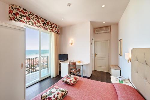 a bedroom with a bed and a view of the ocean at Hotel Bahia in San Benedetto del Tronto