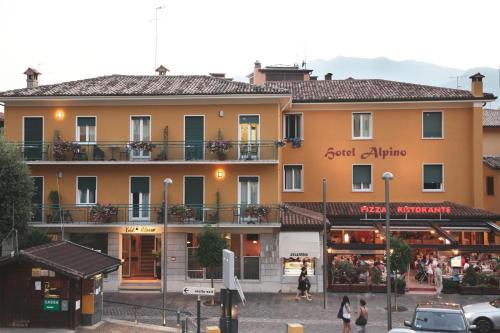 a large building with people walking in front of it at Hotel Alpino in Malcesine