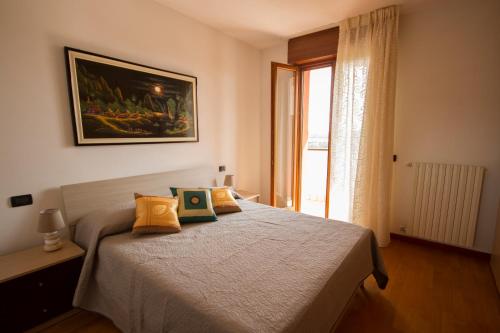 sypialnia z łóżkiem i oknem w obiekcie appartamento a cavallino w Cavallino-Treporti