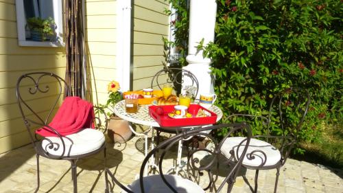 a table and chairs on a patio with food on it at Millygite Cosy Loft in Milly-la-Forêt
