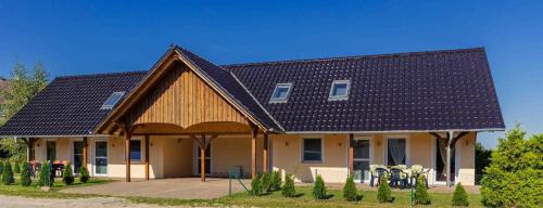 a house with a black roof with a courtyard at Ferienhaus Wiesenblick 16 in Bannemin