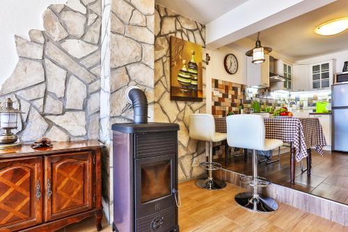 - une cheminée dans la cuisine dotée d'un mur en pierre dans l'établissement Apartment 365, à Tivat