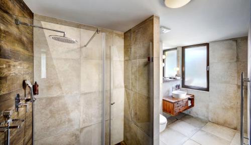 a bathroom with a shower and a toilet and a sink at Hotel Pošta in Demanovska Dolina