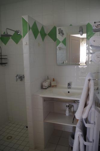 a white bathroom with a sink and a mirror at Les Lavandières in Saint-Hilaire-la-Palud