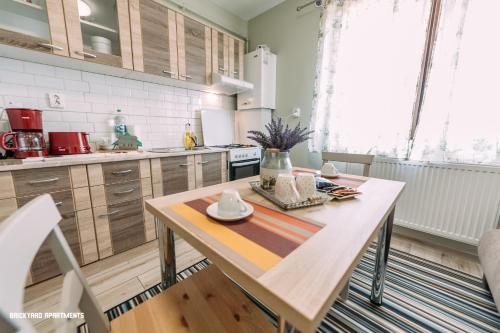 a kitchen with a wooden table in a room at Brickyard Apartments Cluj in Cluj-Napoca