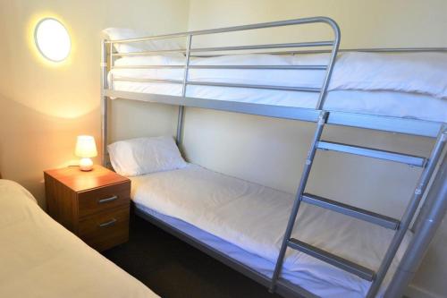 a bedroom with two bunk beds and a night stand at Causeway Coast Apartment in Ballycastle