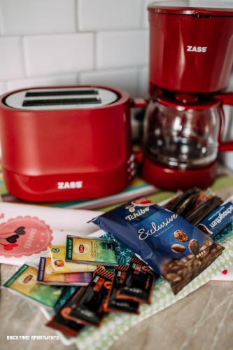 a red toaster sitting next to a pile of food at Brickyard Apartments Cluj in Cluj-Napoca