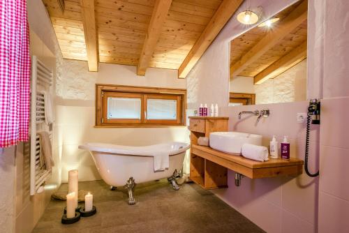 a bathroom with a tub and a sink at Almdorf Almlust in Flachau