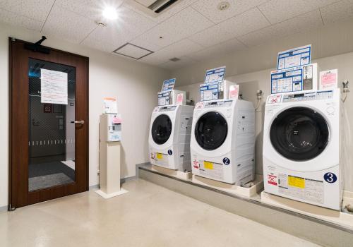 a laundry room with three washing machines on display at Daiwa Roynet Hotel Nagoya Eki Mae in Nagoya