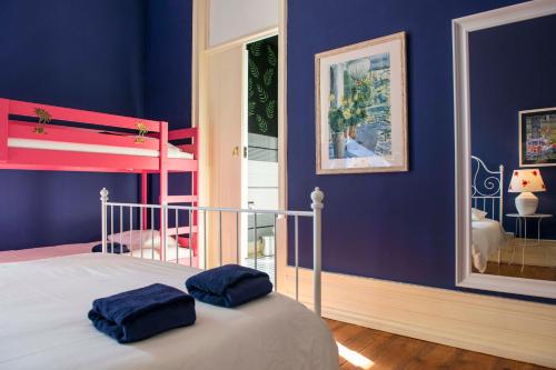 een slaapkamer met blauwe muren en een bed met twee blauwe kussens bij La Palma Hostel Leiria in Leiria