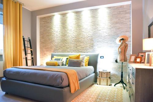 um quarto com uma cama em frente a uma parede de tijolos em Appartamento La Paleologa em Casale Monferrato