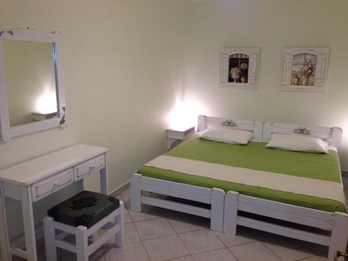 1 dormitorio con cama, escritorio y espejo en Esperia Studios, en Tsoukaladhes